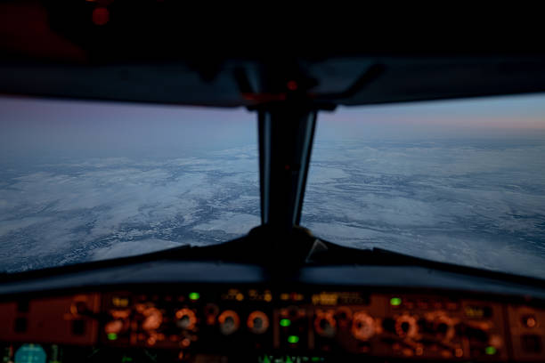 Pilot view from an airbus a320 cockpit flying above clouds during early morning light