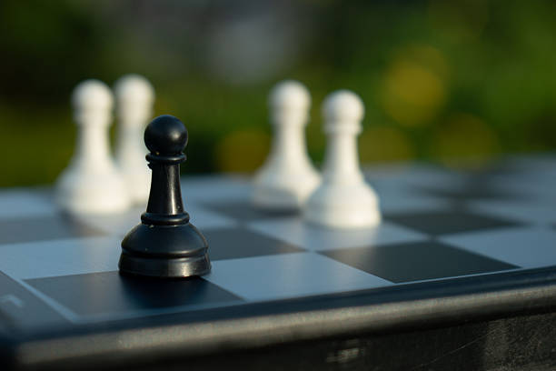 First move. Close up of chessmen on chessboard with the focus on a white pawn.