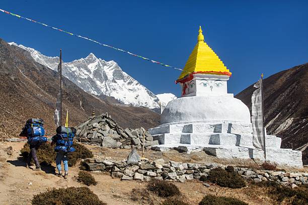 Stupa and prayer flags near Dingboche village with mount Lhotse and two sherpas, way to Everest base camp, Khumbu valley, Solu khumbu, Sagarmatha national park, Nepal himalaya mountain