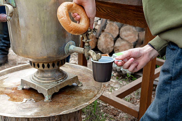 A man pours tea from an antique samovar. Festive food