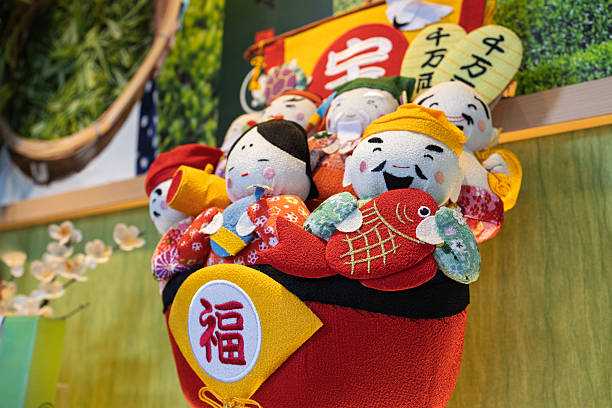 Close-up view of colorful Japanese good luck dolls displayed together in a decorative arrangement. The dolls feature traditional clothing, cheerful expressions, and a visible fortune symbol, representing prosperity, happiness, and East Asian cultural symbolism.