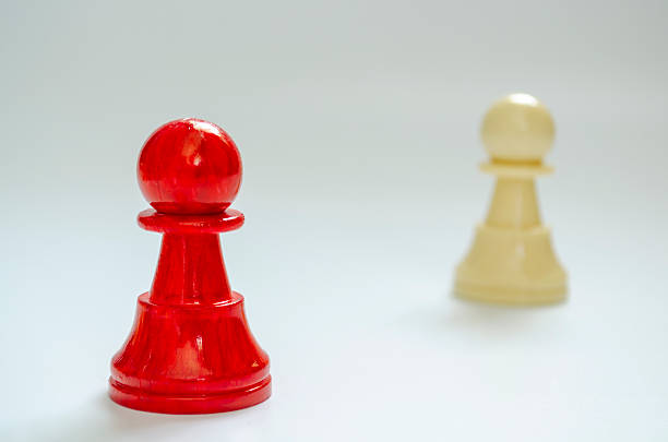 knight chess pieces facing each other illuminated with low light