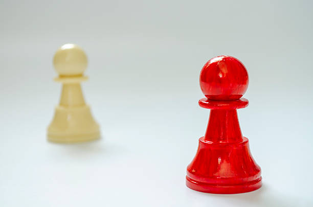 Isolated red pawn with blurred white pawn symbolizing vulnerability and judgment with customizable space for text