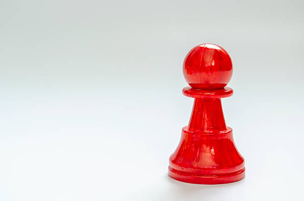 Red pawn standing alone symbolizing courage and individuality