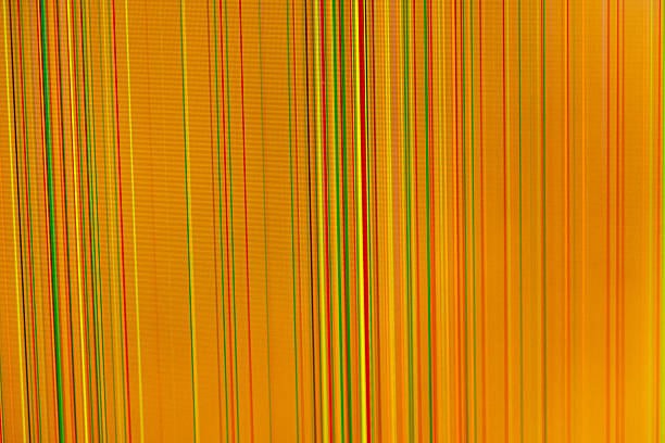 Close-up orange digital display featuring numerous thin red, green, yellow, black vertical lines, conveying malfunctioning screen or visual data distortion