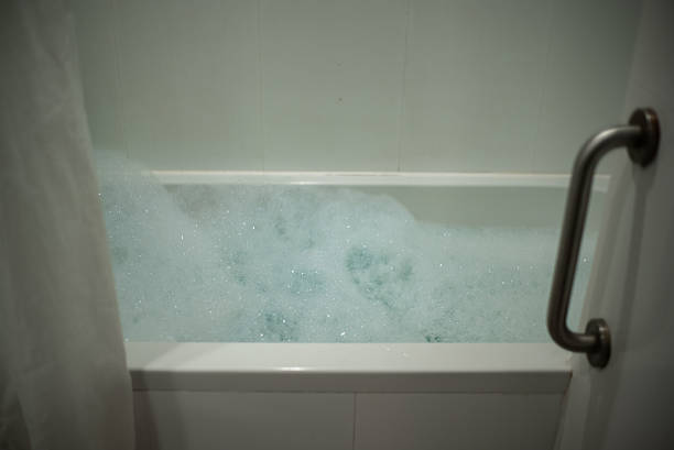A bright bathroom with turquoise and white checkered tiles and a classic white bathtub, creating a vibrant atmosphere with its cheerful color scheme. The setting suggests simplicity and minimalism.