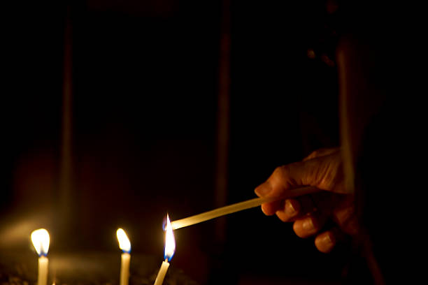 People light candles around the Red Ribbon and pray for those who have lost their lives due to AIDS on the eve of World AIDS Day in Kathmandu, Nepal.