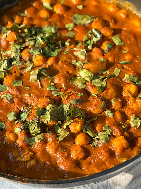 Image of fluffy bhature served with spicy chickpea curry (chole) garnished with fresh coriander leaves, traditional Indian cuisine