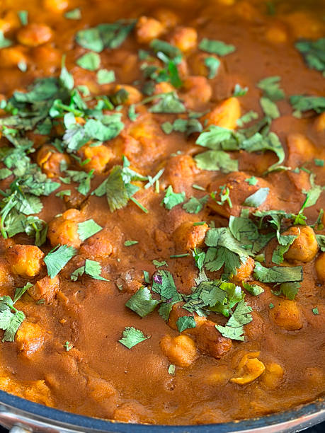 Image of Indian chickpea curry (chole) with bhature, garnished with fresh coriander leaves, showcasing traditional Indian cuisine