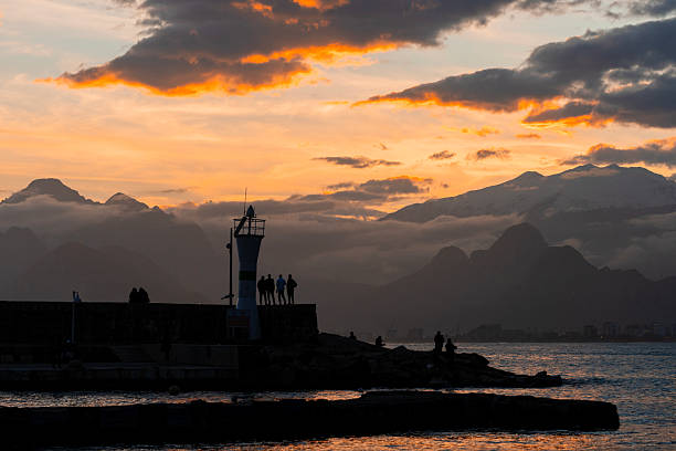Dramatic Sunset Over the Taurus Mountains with People Silhouettes on a Pier