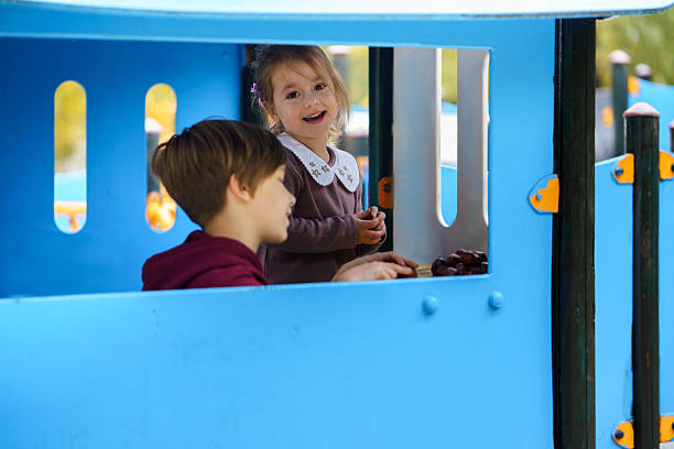Young children having fun together on blue playground structure.