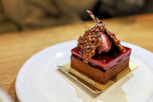 Close-up of a chocolate dessert served on a white plate at a cafe table. The image highlights fine dessert presentation, indulgence, and modern cafe dining in a relaxed lifestyle setting.