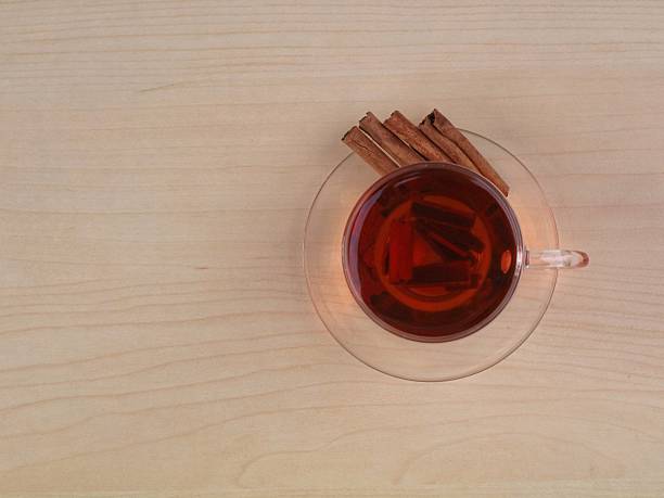 Close-up of Cinnamon sticks in a glass bowl isolated against plain white background. Cinnamon plays a major role in Indian spices, recipes and ayurvedic herbal remedies.