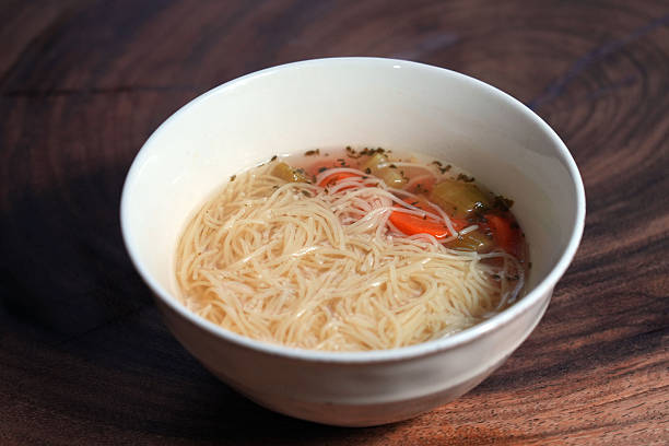A hot bowl of soup with Chicken, Noodles, Carrots, Celery and Matzo Balls.