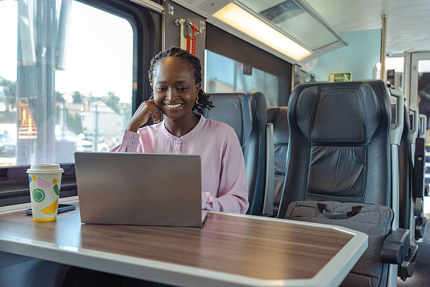 istock Young woman working on a laptop during a train commute, smiling and focused 2259447588