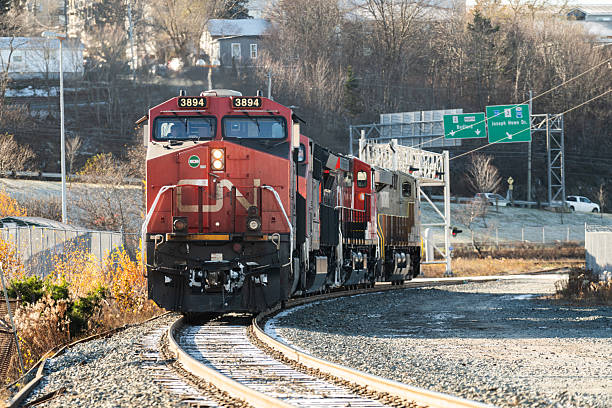 Fraser Canyon, Canada - April 28, 2024: CN  2706 pulls CN 5730 and freight cars south near the Fraser River. Spring afternoon in the Coast Mountain Range.