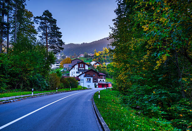 winding asphalt road leading to the ski resort of Malbun, passing through the chalet village of Triesenberg with autumn trees in Liechtenstein