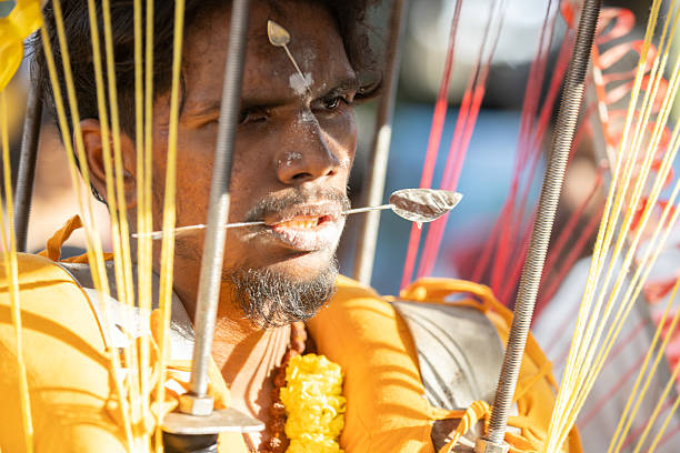 01 February 2026, George Town - Penang Island.A devotee carries a kavadi with vels piercing his forehead and cheeks during the Thaipusam festival, demonstrating determination, devotion, and penance to Lord Murugan.