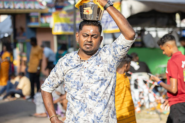 01 February 2026, George Town - Penang Island.A devotee walks through the festival area balancing a small kavadi on his head. This personal act of devotion demonstrates commitment and respect for Lord Murugan during the celebrations.