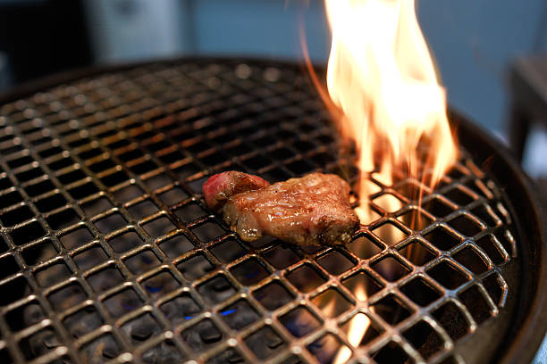 Grilling Wagyu Beef on Barbecue Grill with Chopsticks