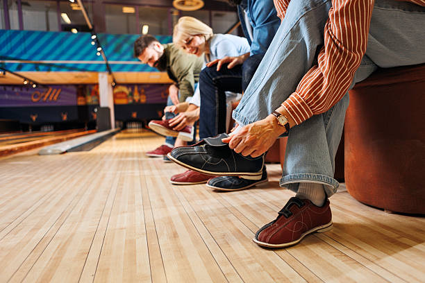 Group of Friends Putting on Bowling Shoes Before Game