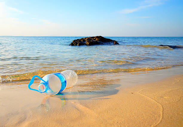 Plastic bottle waste on sea beach. Ocean pollution. Marine litter. Garbage plastic bottle on sand beach. Plastic marine debris. Marine plastic pollution. Microplastics poisoning. Garbage in Ocean.