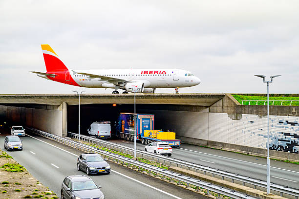 Iberia Airbus A320-200 crossing the A5 highway at Schiphol Amsterdam Airport after landing at the Polderbaan runway. China Cargo Airlines (CCA) is a cargo airline with its head office on Changning District in Shanghai, People's Republic of China.