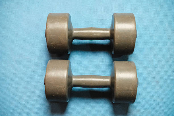 The image is part of a series of photos taken in belonging focusing on tools necessary for a home workout such as dumbbells, bench and mat