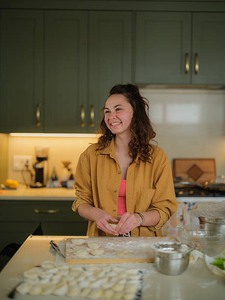Woman making dumplings at her domestic kitchen