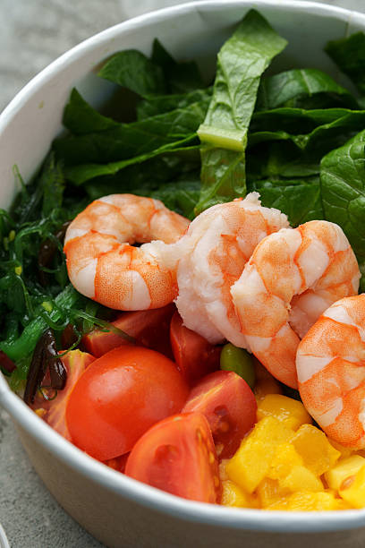 Shrimp salad bowl with fresh greens and tomatoes for a healthy meal
