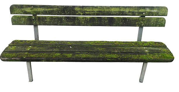 Weathered wooden park bench shows signs of aging and natural decay, creating an isolated object