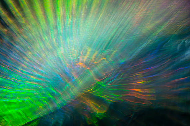 Luminous green, blue, and amber light streams radiate in long exposure, creating an abstract surge of motion that conveys emotion, energy, and depth.