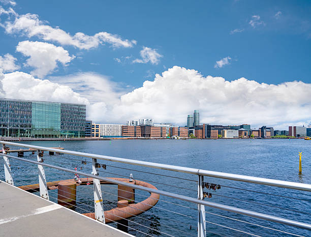 Bryggebroen bridge in Copenhagen Denmark with skyline of modern waterfront buildings and cloudy sky