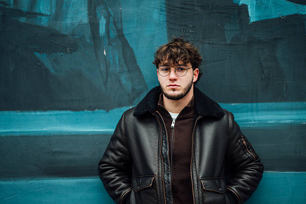 Young man in winter clothes posing outoors and looking at camera