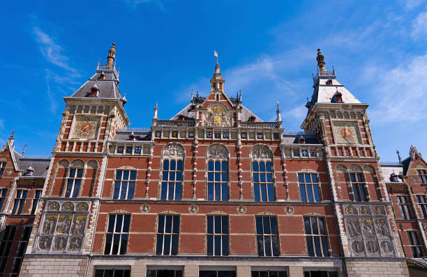 Amsterdam Central Station red brick historic facade in Netherlands under sunny sky
