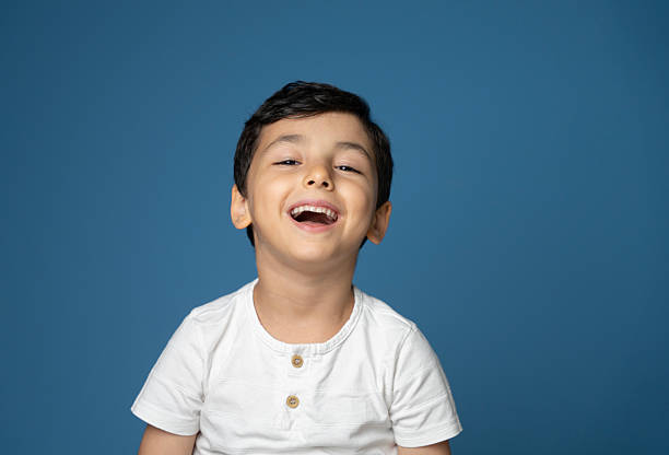 istock Laughing Cute little boy portrait , Studio shot, blue wall background 2259562595