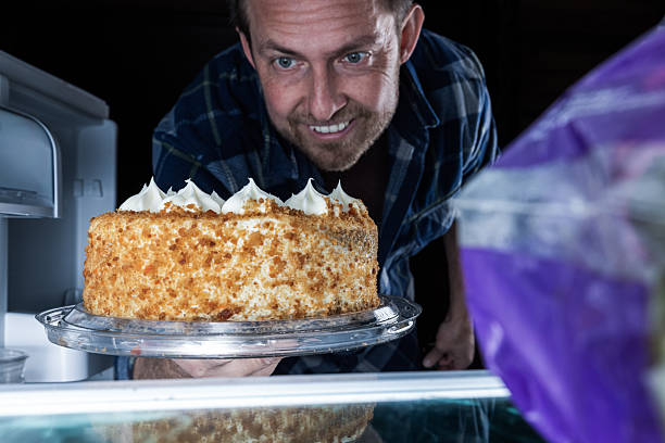 Image of a male pastry chef making a strawberry shorthole cake with a confused expression
