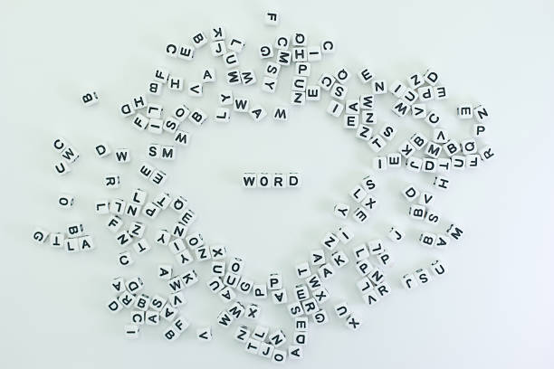 Letter tiles are scattered on a white surface, forming a unique pattern. The focus is on the word WORD made from the same tiles. This activity appears to be playful and engaging.