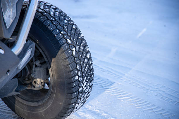 Car with snow tires on snowy road. High-quality commercial stock image.