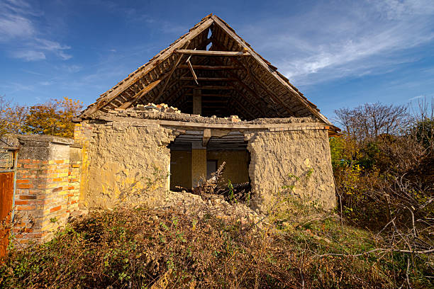 Abandoned neglected old adobe house made with bricks of mud, clay and straw with hole in wall.
