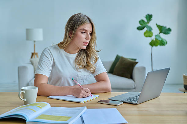 istock Young woman university student sitting at desk with laptop, typing writing studying 2259596009