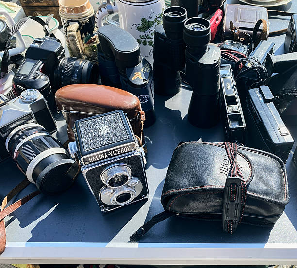 Vienna, Austria - July 13, 2024: Vintage cameras and binoculars are arranged on a table at a flea market, showcasing leather cases and accessories