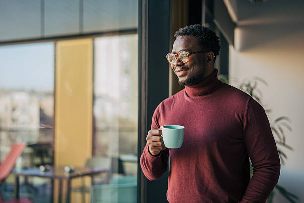 istock Man enjoying morning coffee looking out window 2259608366