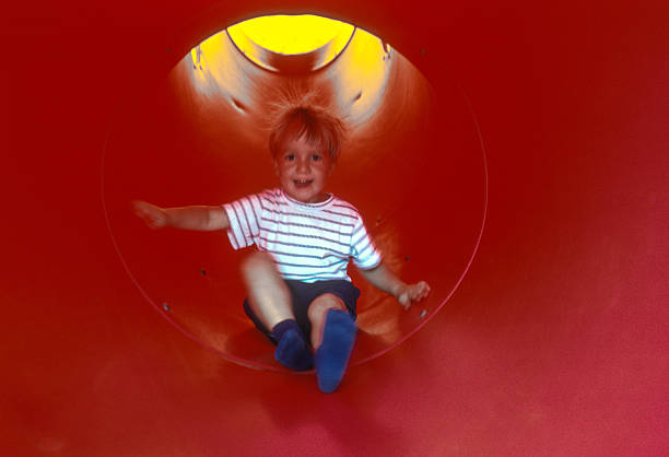 Tennessee - Boy, coming down a red slide - 1991. Scanned from Kodachrome 64 slide.