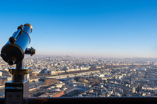 Close up vintage telescope on the Eiffel Tower observation deck, Panoramic view of Paris skyline featuring the Sacre-Coeur Basilica on Montmartre hill, dense urban landscape with classic architecture