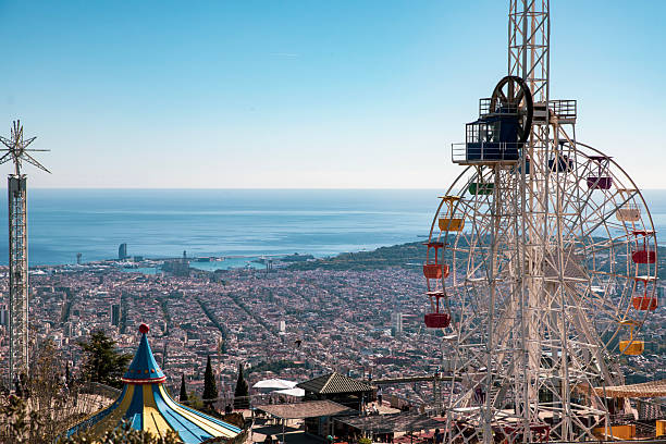 Tibidabo Amusement Park located on the Tibidabo Mountain looms over the townscape of Barcelona, Spain. Panoramic Area with view as far as Montserrat, on a clear sunny day