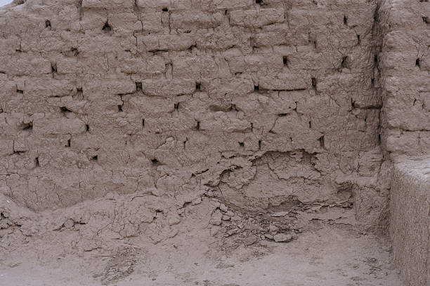Toprak Kala displays extensive mud-brick ruins with fortification walls spread across desert landscape in Khorezm region, Uzbekistan. The ancient site showcases characteristic Khorezmian architecture with pisé construction, defensive walls, and archaeological remains of important urban center. The composition captures the impressive scale of the ruins and historical significance of this major ancient city in the Kyzylkum Desert.