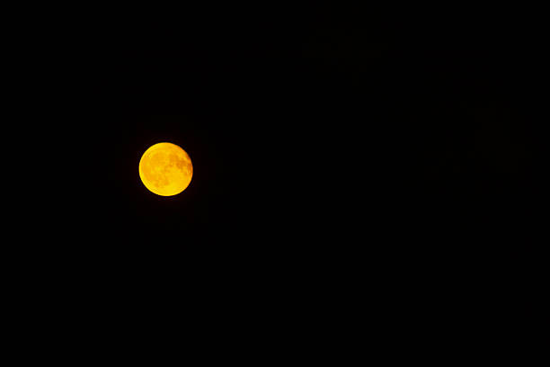 warm harvest moon over dark sky, visible craters and amber tones create nostalgic romantic mood, evocative seasonal energy suited