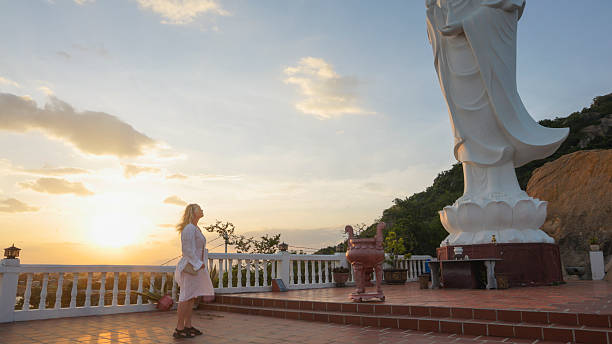 Mature woman explores Buddhist temple on mountain at sunset, Trung Khanh, Phan Rang