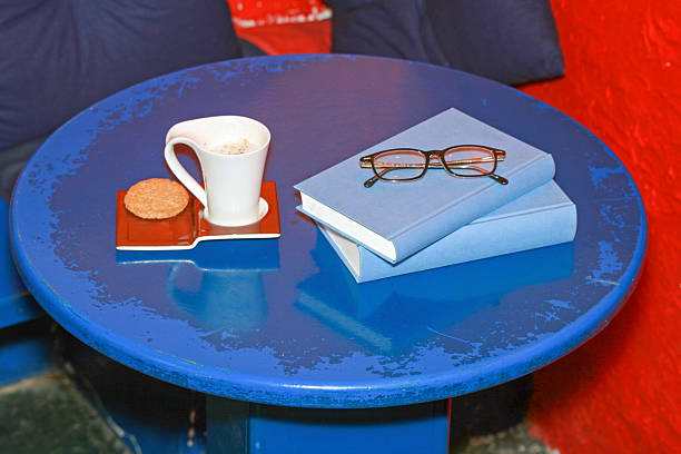 Coffee Cup Cookie at Tray Books With Reading Glasses at Blue Table Top